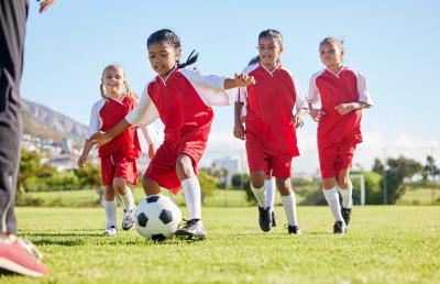 School age children in red uniforms playing soccer