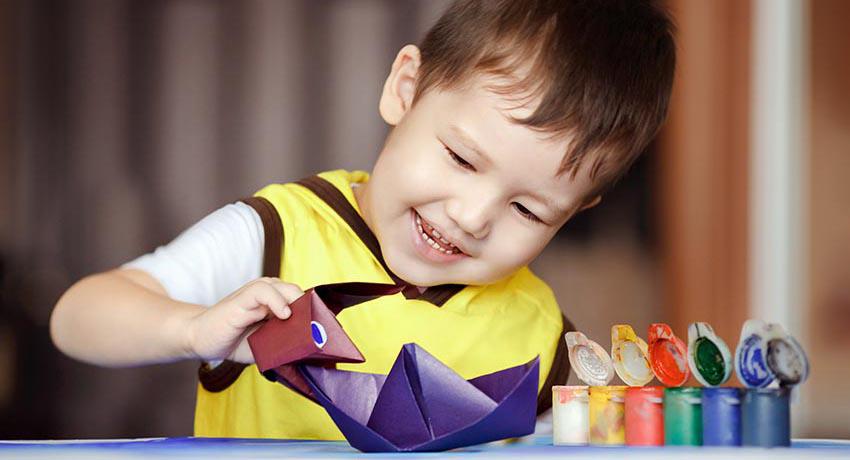 young boy with paper boat