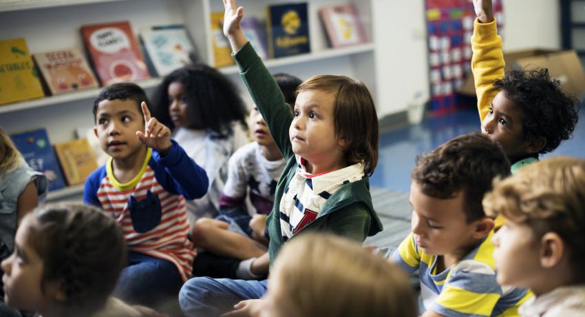 Group of children raising their hands during floor time