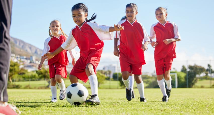 School age children in red uniforms playing soccer